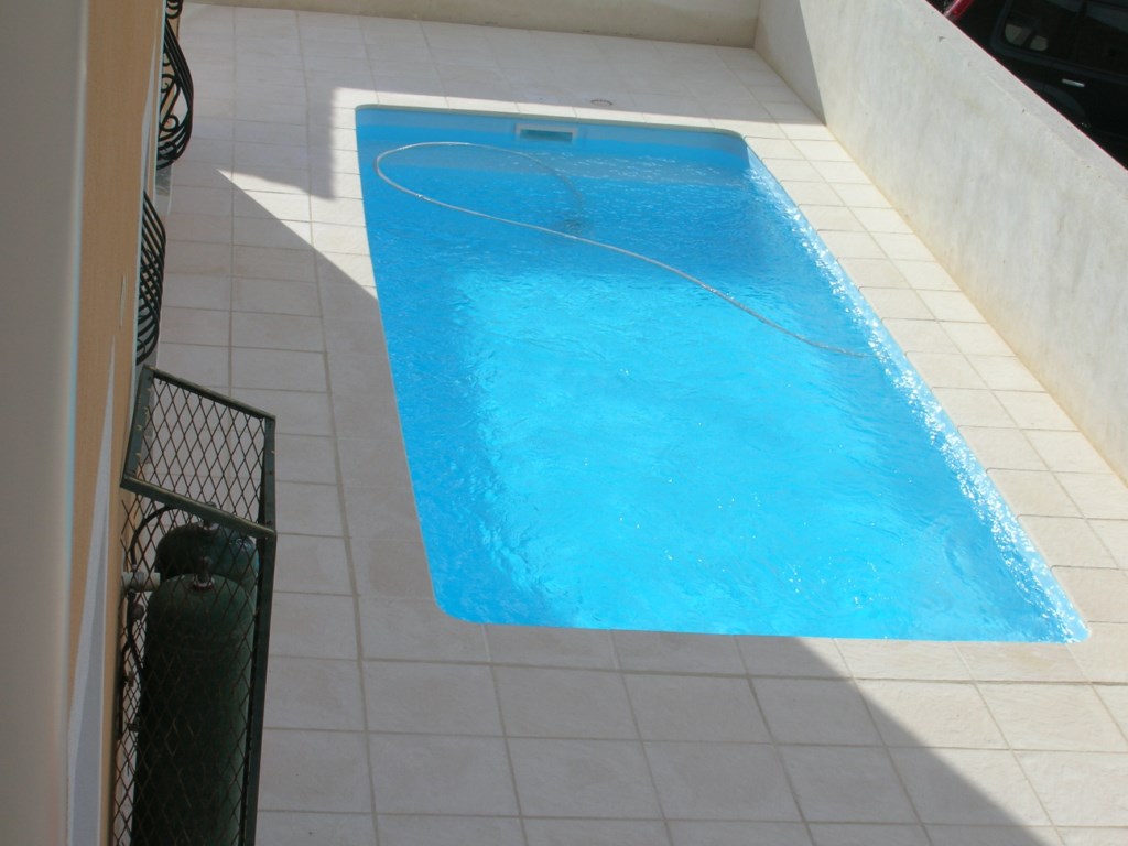 Coque polyester ovoide blanche avec dallage autour fond plat et banquette Harmony Jupiter  Ferre Piscines à Allauch