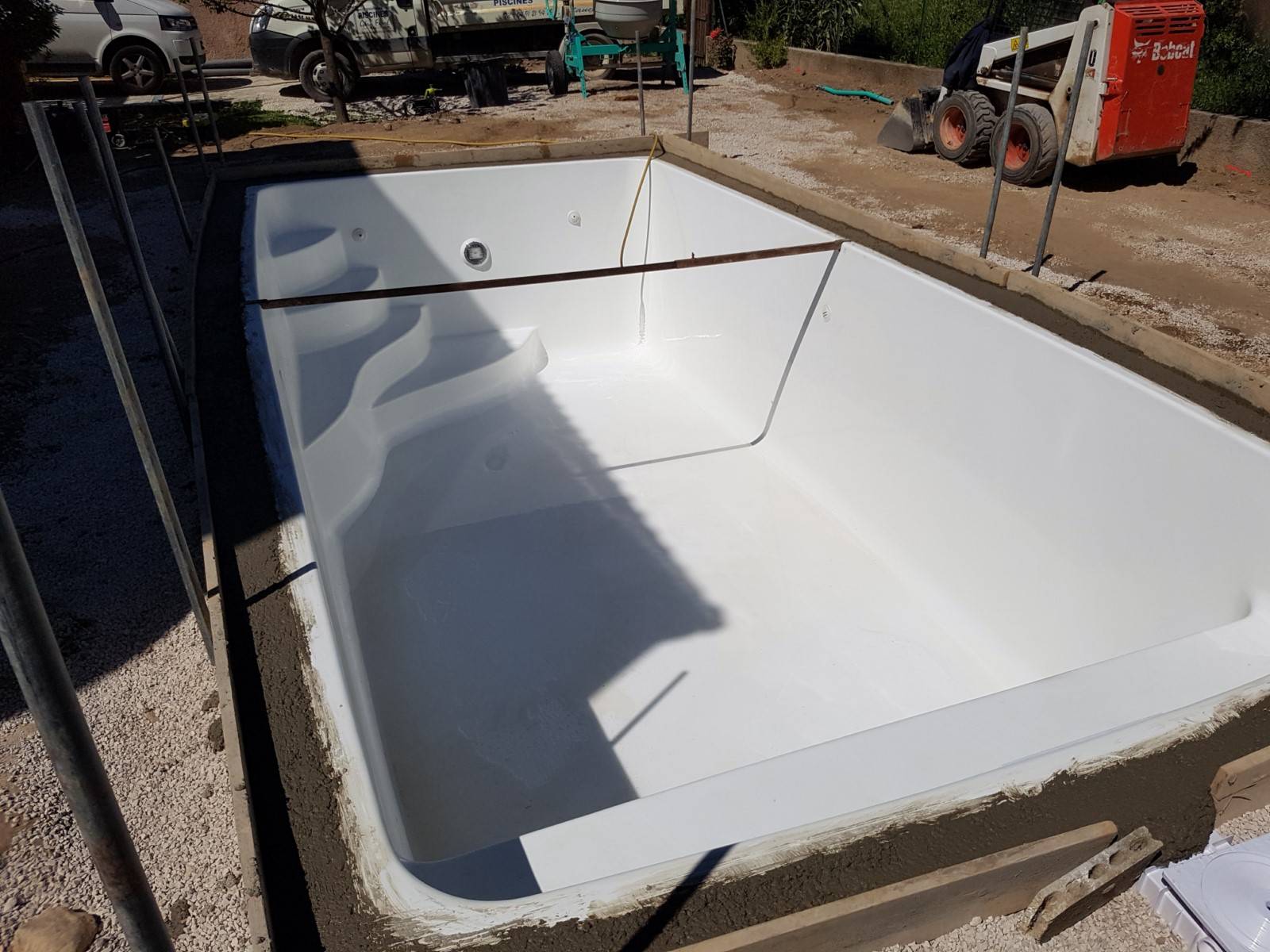 Coque polyester ovoide blanche avec dallage autour fond plat et banquette Harmony Jupiter  Ferre Piscines à Allauch