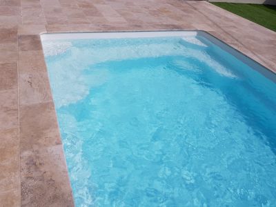 Dallage en Travertin autour de piscine coque polyester blanche fond progressif Ferré Piscines 13